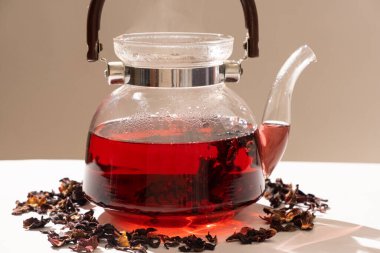 Red hibiscus tea from the petals of a Sudanese rose in a glass teapot.