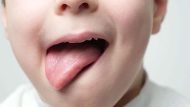 Kleine Süße Junge Zeigt Seine Zunge Und Leckt Mund Nahaufnahme — Stockvideo