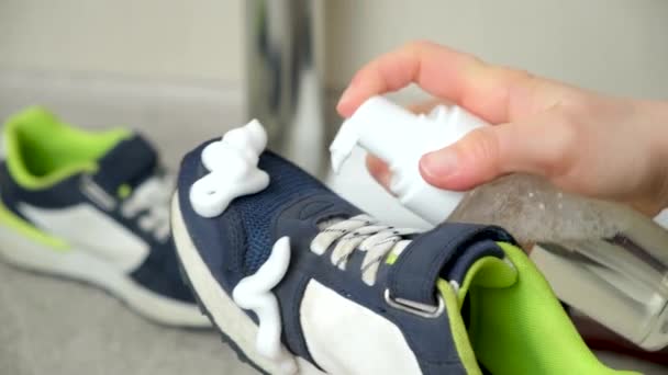 用清洁剂把瓶子上的泡沫涂在孩子们的蓝色面料运动鞋上 照顾鞋子 清理灰尘和泥土 — 图库视频影像