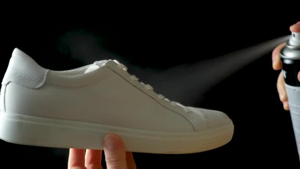 撥水性のある疎水性スプレーを白い女性のスニーカーに塗布します 不快な臭いからの靴の保護 — ストック動画