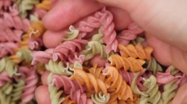 Bir avuç dolusu glütensiz pirinçli makarna domates, kereviz ve havuçlu fusilli..