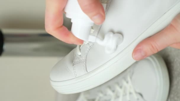 ボトルから白い革の女性のスニーカーにクリーニング泡を適用します 革の靴のケア 表面の白化 — ストック動画