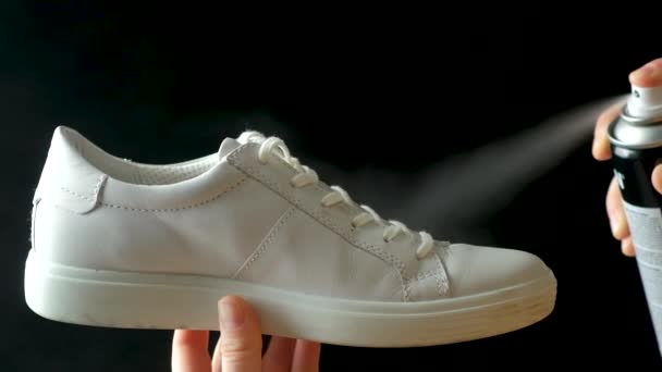 撥水性のある疎水性スプレーを白い女性のスニーカーに塗布します 不快な臭いからの靴の保護 — ストック動画