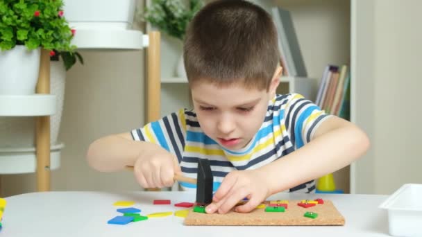 Przedszkolak Bawi Się Mozaiką Buduje Figury Planszy Młotkując Gwoździe Młotkiem — Wideo stockowe
