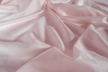 Abstract pink fabric background, satin stripe texture, wavy folds of elegant expensive fabric.
