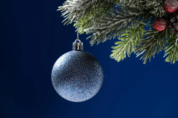 Голубой Блестящий Шар Заснеженной Ветке Рождественской Елки Синем Фоне Место — стоковое фото