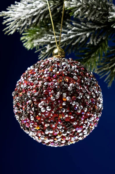 圣诞树上被雪覆盖的树枝上闪烁着美丽的红球 这是新的一年里的垂直卡片 — 图库照片