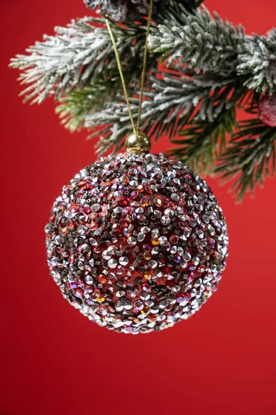 Shiny Pink Ball Snow Covered Branch Christmas Tree Red Background — Stock Photo, Image