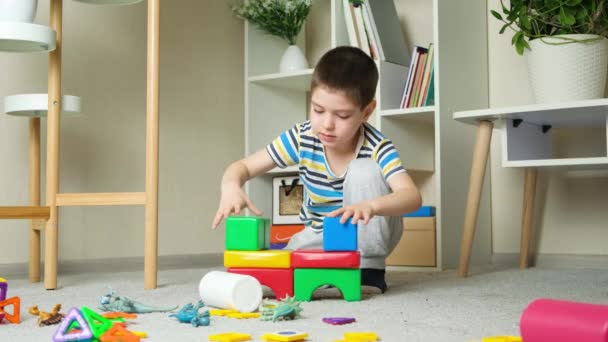 Bambino Costruisce Una Torre Castello Cubi Seduti Sul Pavimento Nella — Video Stock