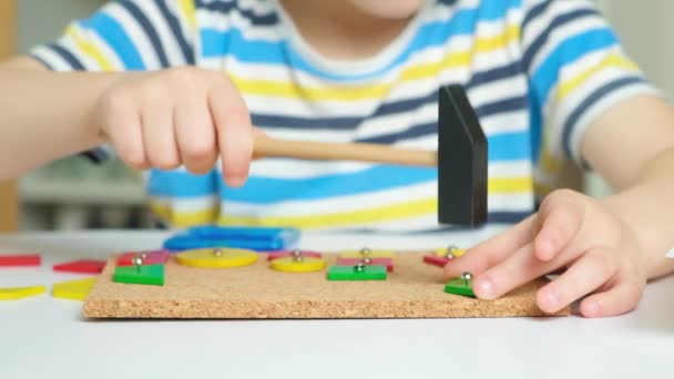 Ett Förskolebarn Leker Med Mosaik Bygger Figurer Bräda Hamrar Naglar — Stockvideo