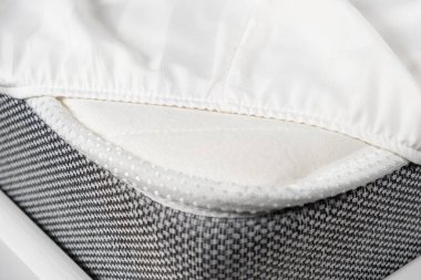 White satin sheet on an elastic band on the mattress. Bed linen on the bed.