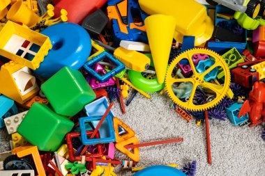Çocuk odasında bir sürü oyuncak var. Tasarımcılardan bir sürü plastik renkli parça. Oyuncaklar, heykelcikler ve küpler için yedek parça.
