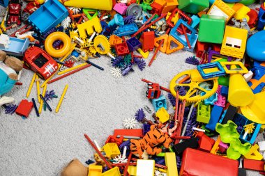 Çocuk odasında bir sürü oyuncak var. Tasarımcılardan bir sürü plastik renkli parça. Oyuncaklar, heykelcikler ve küpler için yedek parça.