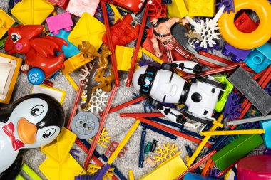 Çocuk odasında bir sürü oyuncak var. Tasarımcılardan bir sürü plastik renkli parça. Oyuncaklar, heykelcikler ve küpler için yedek parça.