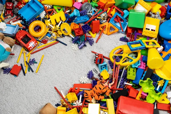 An abundance of toys in the children\'s room, a lot of plastic multi-colored parts from designers, spare parts for toys, figurines and cubes