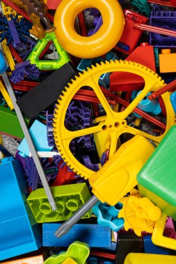 Çocuk odasında bir sürü oyuncak var. Tasarımcılardan bir sürü plastik renkli parça. Oyuncaklar, heykelcikler ve küpler için yedek parça.