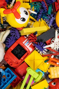 Çocuk odasında bir sürü oyuncak var. Tasarımcılardan bir sürü plastik renkli parça. Oyuncaklar, heykelcikler ve küpler için yedek parça.