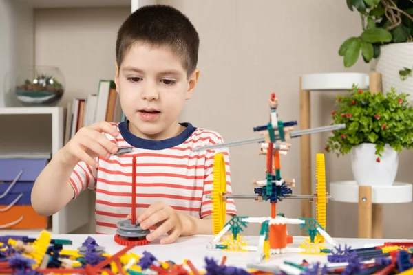 Mały Chłopiec Bawi Się Konstruktorem Tworząc Figury Kół Zębatych Kijów — Zdjęcie stockowe