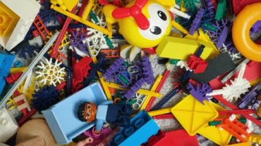 Çocuk odasında bir sürü oyuncak, tasarımcılardan bir sürü plastik renkli parça, oyuncaklar, heykelcikler ve küpler için yedek parçalar.