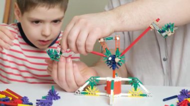 Baba ve oğul inşaatçıdan figürler yapıyorlar. Birlikte zaman geçirmek, çocuğun hayatındaki baba rolü..