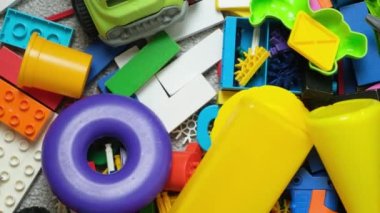 Çocuk odasında bir sürü oyuncak, tasarımcılardan bir sürü plastik renkli parça, oyuncaklar, heykelcikler ve küpler için yedek parçalar.