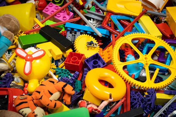 Çocuk odasında bir sürü oyuncak, tasarımcılardan bir sürü plastik renkli parça, oyuncaklar, heykelcikler ve küpler için yedek parçalar.