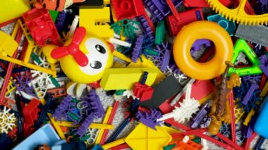 Çocuk odasında bir sürü oyuncak, tasarımcılardan bir sürü plastik renkli parça, oyuncaklar, heykelcikler ve küpler için yedek parçalar.
