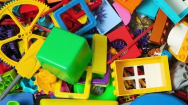 Çocuk odasında bir sürü oyuncak, tasarımcılardan bir sürü plastik renkli parça, oyuncaklar, heykelcikler ve küpler için yedek parçalar.