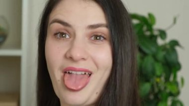 Kameraya dönüp dilini dışarı çıkaran çılgın bir esmer kadının portresi.