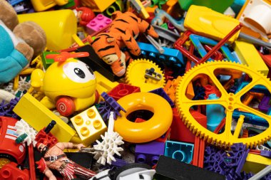 Çocuk odasında bir sürü oyuncak var. Tasarımcılardan bir sürü plastik renkli parça. Oyuncaklar, heykelcikler ve küpler için yedek parça.