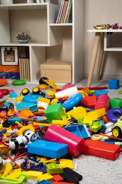 Çocuk odasında bir sürü oyuncak var. Tasarımcılardan bir sürü plastik renkli parça. Oyuncaklar, heykelcikler ve küpler için yedek parça.