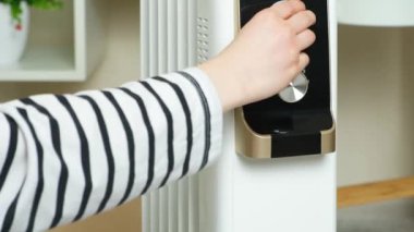 Isıtıcıyı kapatıyorum. El, yağ ısıtıcısının güç ve sıcaklık seviyesini yükseltiyor. Evde iklim kontrolü