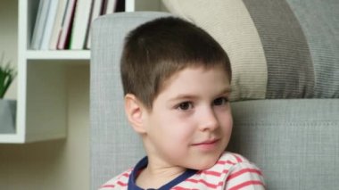 5 yaşındaki bir çocuk başını çevirir ve gülümseyen kameraya bakar.