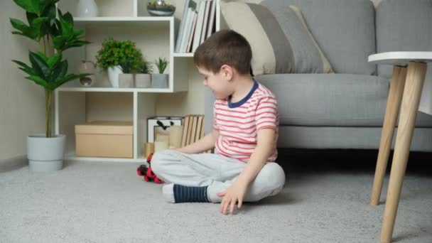 Roztomilý Letý Chlapec Hraje Hračkou Stroj Zatímco Sedí Blízkosti Gauče — Stock video