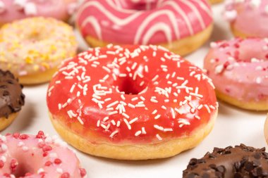 Kırmızı ve pembe jöleli çörekler, üst manzara. Bir sürü çörek, tatlı ve lezzetli yemekler..