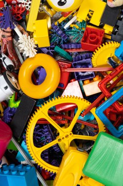 Çocuk odasında bir sürü oyuncak, tasarımcılardan bir sürü plastik renkli parça, oyuncaklar, heykelcikler ve küpler için yedek parçalar.