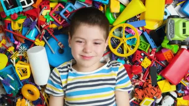 一个5岁男孩在分散的玩具背景下的肖像 童年时代快乐 玩具繁多 — 图库视频影像
