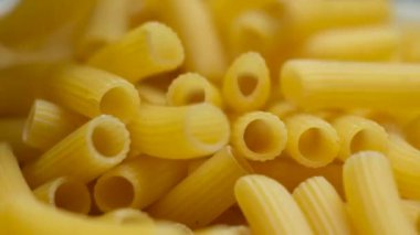 Uçan buğday makarna Rigatoni tüpler halinde tepeden tırnağa, yakın çekim, yavaş çekim