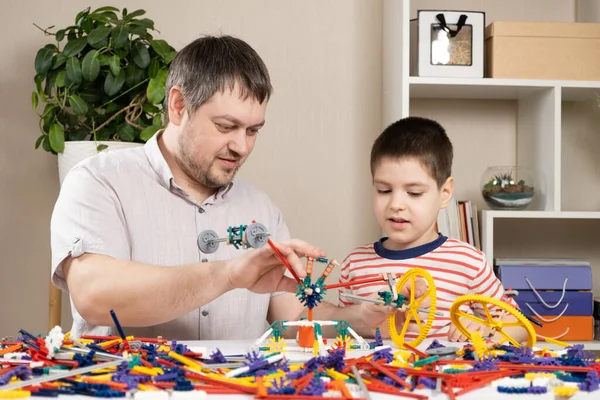 Dad and son build figures from the constructor. Spending time together, the role of the father in the childs life.
