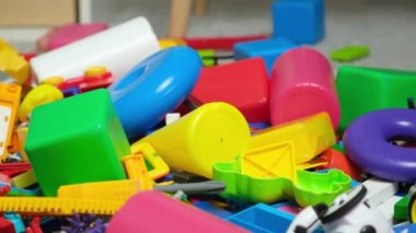 Çocuk odasında bir sürü oyuncak, tasarımcılardan bir sürü plastik renkli parça, oyuncaklar, heykelcikler ve küpler için yedek parçalar.
