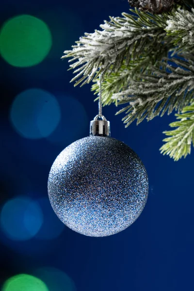 Голубой Блестящий Шар Заснеженной Ветке Рождественской Елки Синем Фоне — стоковое фото