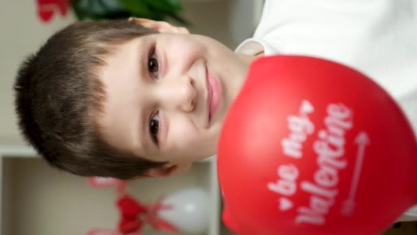 可爱的5岁男孩拿着一个气球 上面的文字是我的情人 微笑着看着摄像机 — 图库视频影像