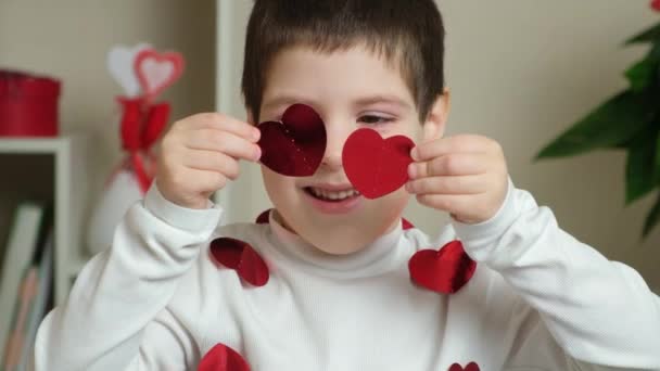 情人节那天 可爱的学龄前小男孩带着心形的花环玩耍 — 图库视频影像