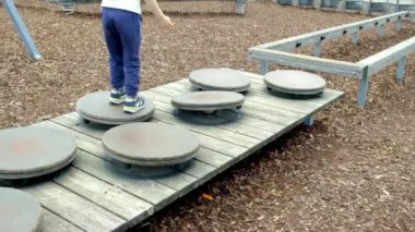 Çocuk parkında oynayan 5 yaşındaki bir çocuk dengesini geliştiriyor..