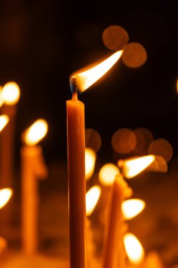 Karanlıkta tapınakta bir sürü yanan mum var. Din, dua ve Tanrı kavramı.