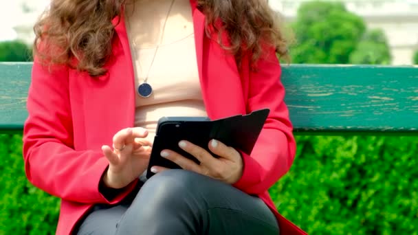 Uma Mulher Usa Seu Telefone Enquanto Senta Banco Parque — Vídeo de Stock