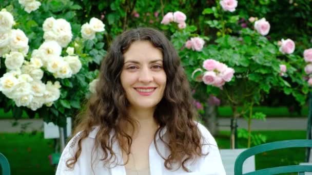 Bahçede Çiçek Açan Güllerin Arka Planında Duran Yaşındaki Doğal Saçlı — Stok video