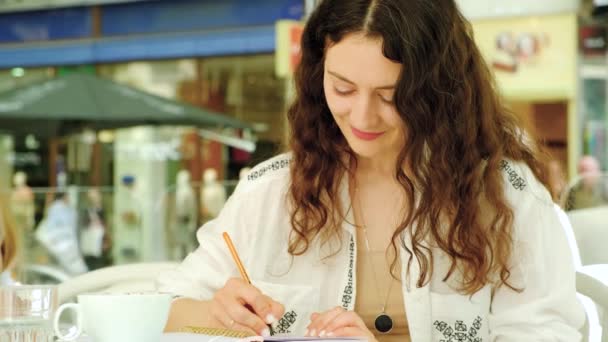 Vacker Ung Kvinna Ett Café Sitter Och Skriver Med Penna — Stockvideo