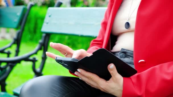 Uma Mulher Usa Seu Telefone Enquanto Senta Banco Parque — Vídeo de Stock
