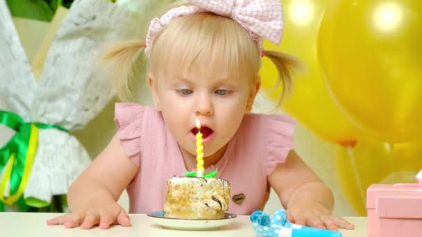 漂亮的生日女孩头上顶着两条马尾辫 吹灭了生日蛋糕上的蜡烛 — 图库视频影像